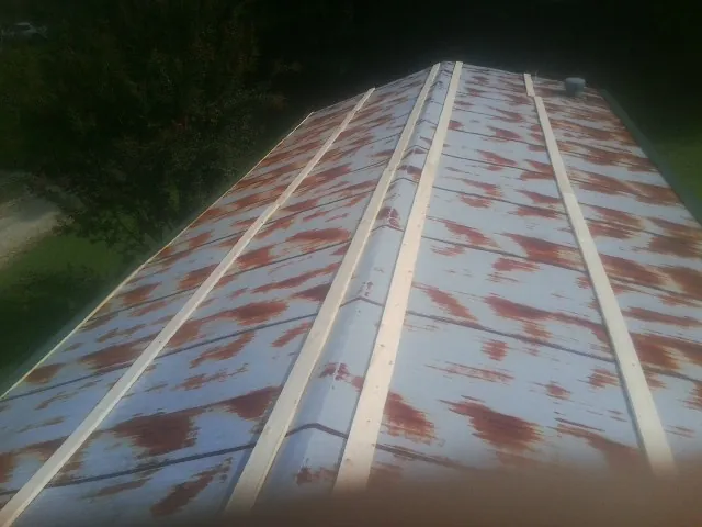 Rusted metal roof panels with new wood purlins before replacement — Storm Damage Roof Repair in Saint Benedict by Roofing Brothers